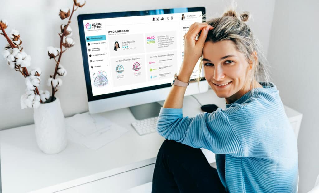 Girl smiling with LTS platform on the computer screen behind her